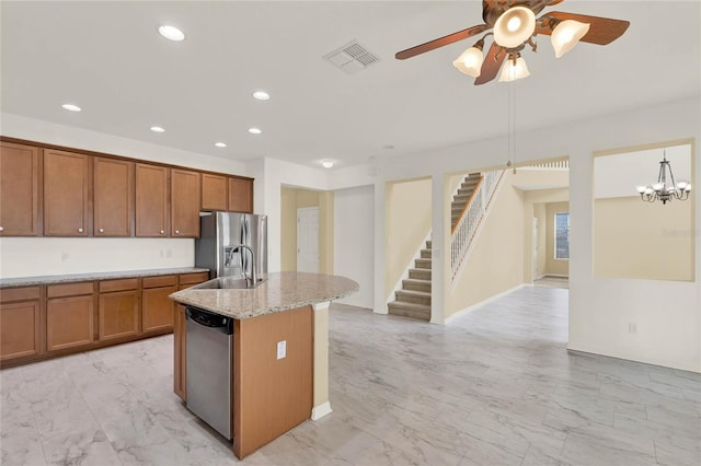 kitchen with light stone countertops, sink, a center island with sink, ceiling fan with notable chandelier, and appliances with stainless steel finishes