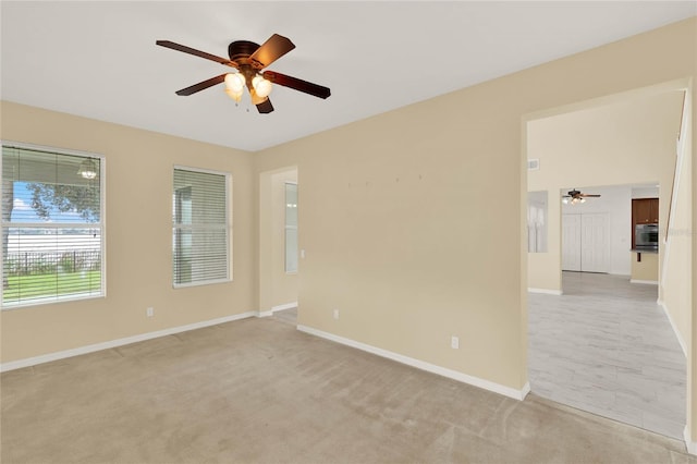 spare room featuring ceiling fan and light colored carpet