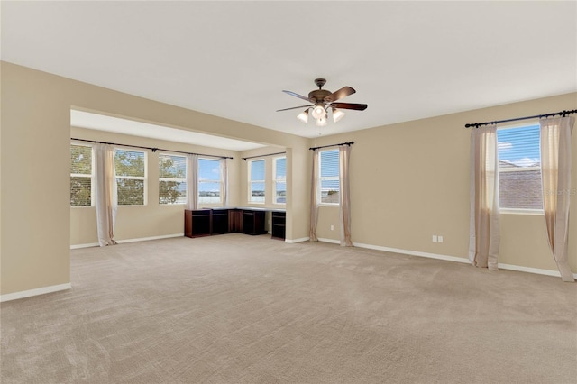 carpeted spare room featuring ceiling fan