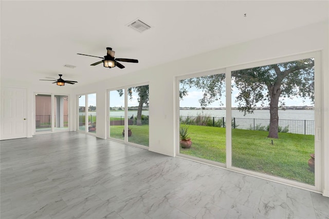 unfurnished sunroom with ceiling fan and a water view