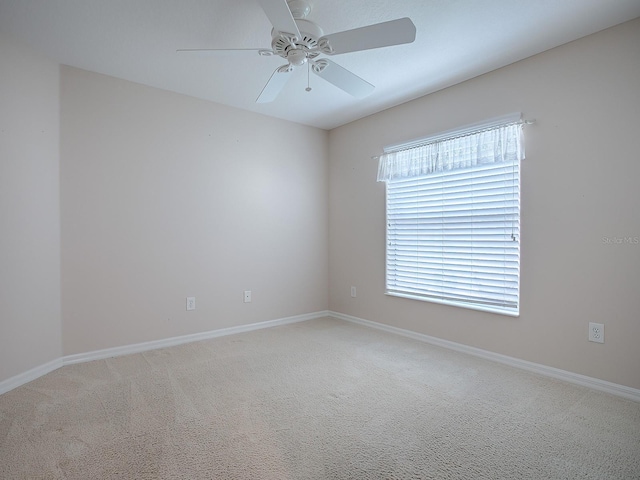 carpeted spare room featuring ceiling fan