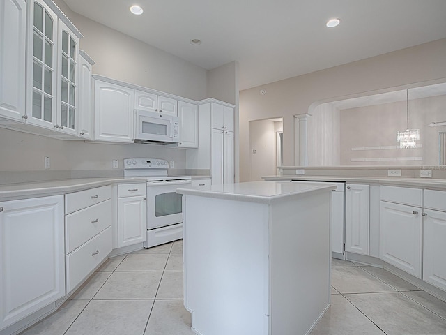 kitchen featuring white cabinets, pendant lighting, white appliances, and a kitchen island