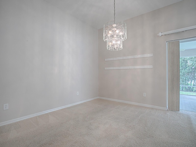 empty room with carpet floors and an inviting chandelier