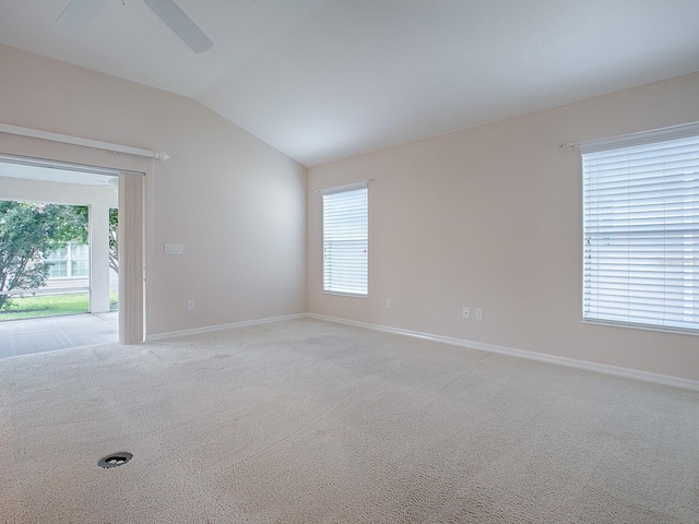 spare room with light colored carpet, vaulted ceiling, and ceiling fan