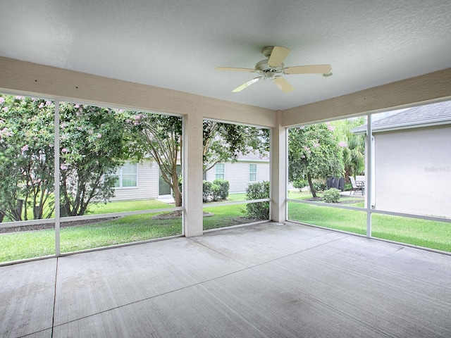 unfurnished sunroom with a wealth of natural light and ceiling fan