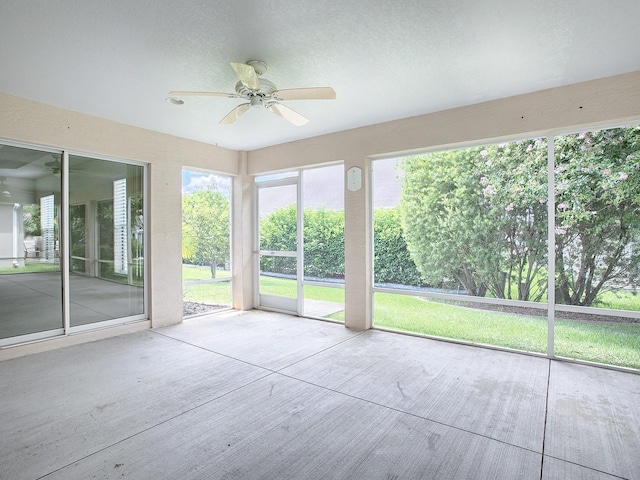 unfurnished sunroom featuring ceiling fan