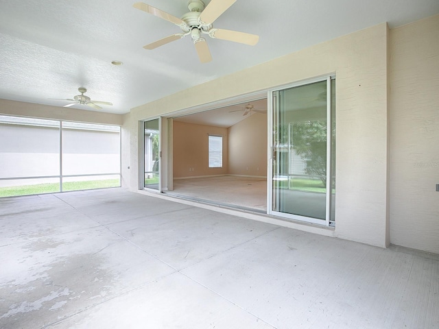 unfurnished sunroom featuring ceiling fan