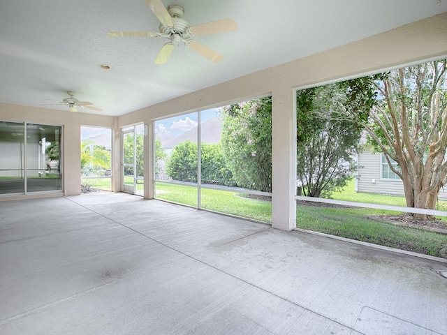 unfurnished sunroom with ceiling fan