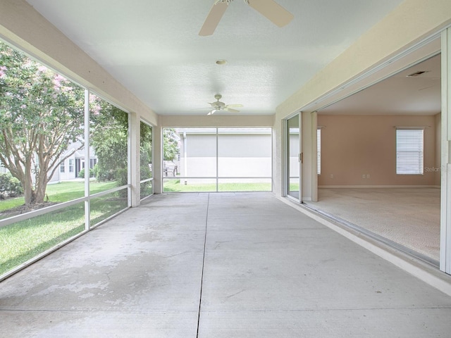 unfurnished sunroom featuring ceiling fan