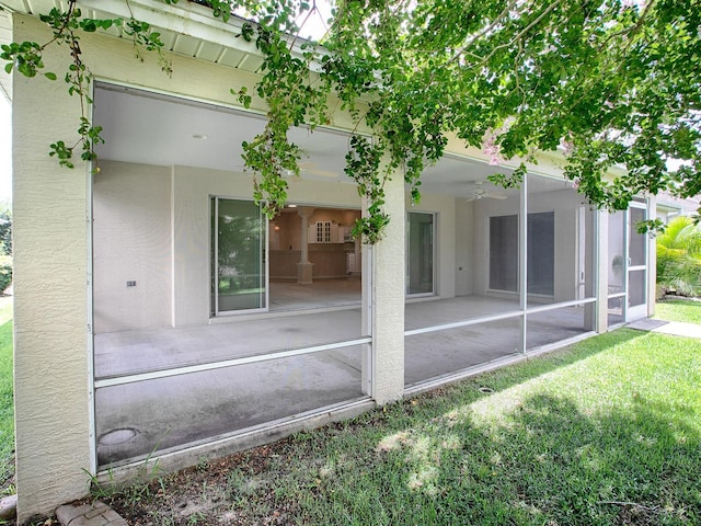 rear view of house featuring a sunroom and a yard