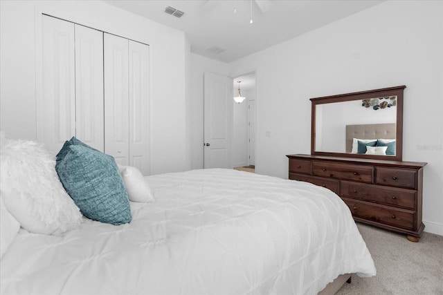 carpeted bedroom with ceiling fan and a closet