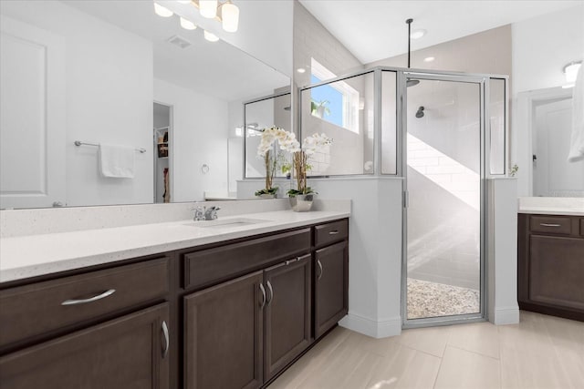 bathroom with vaulted ceiling, an enclosed shower, vanity, and tile patterned flooring