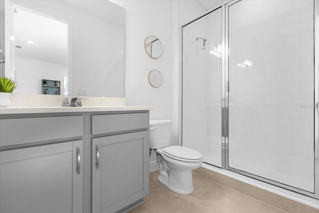 bathroom with toilet, a shower with door, tile patterned floors, and vanity