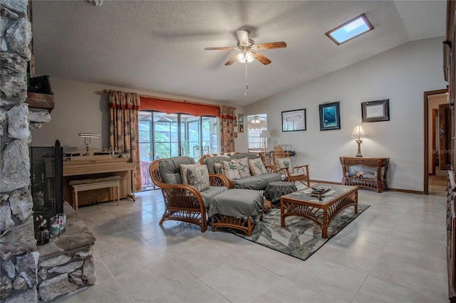 living area with a ceiling fan, lofted ceiling, a textured ceiling, and baseboards