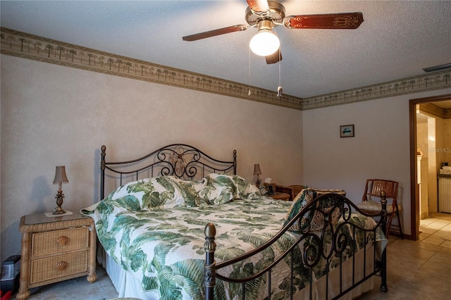 bedroom featuring a textured ceiling, light tile patterned flooring, visible vents, and a ceiling fan