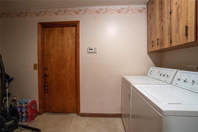 laundry area featuring a textured ceiling, baseboards, cabinet space, and washer and dryer