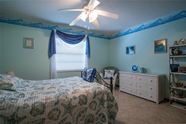 bedroom with light tile patterned floors, a ceiling fan, and a textured ceiling