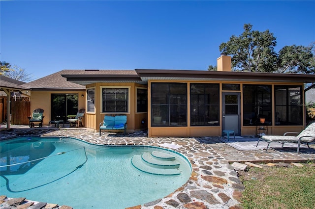 outdoor pool with a sunroom, a patio area, and fence