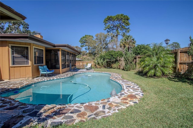 view of swimming pool featuring fence private yard, a sunroom, and a yard