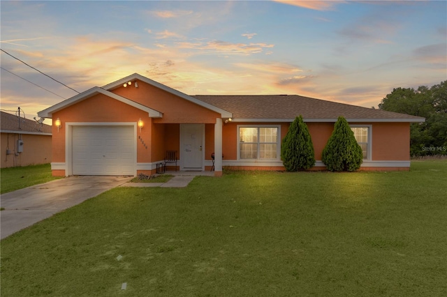 ranch-style house with a garage and a lawn