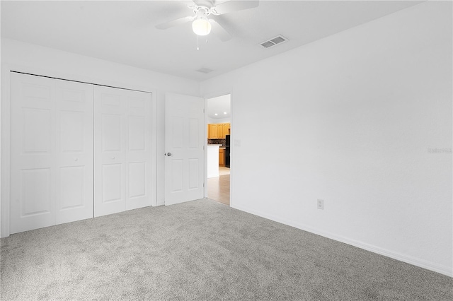 unfurnished bedroom with carpet floors, a closet, and ceiling fan