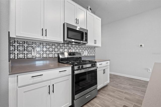 kitchen with backsplash, white cabinetry, light hardwood / wood-style floors, and appliances with stainless steel finishes