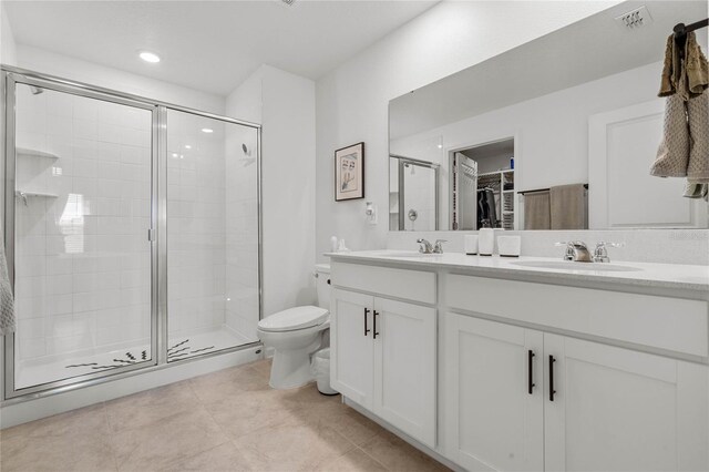 bathroom featuring tile patterned floors, vanity, toilet, and walk in shower