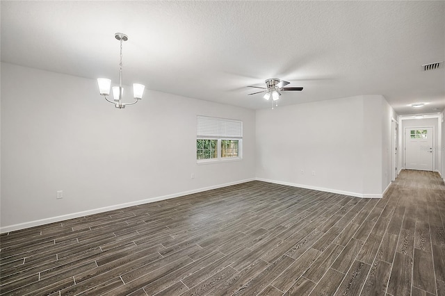 empty room featuring ceiling fan with notable chandelier, dark hardwood / wood-style flooring, and a textured ceiling