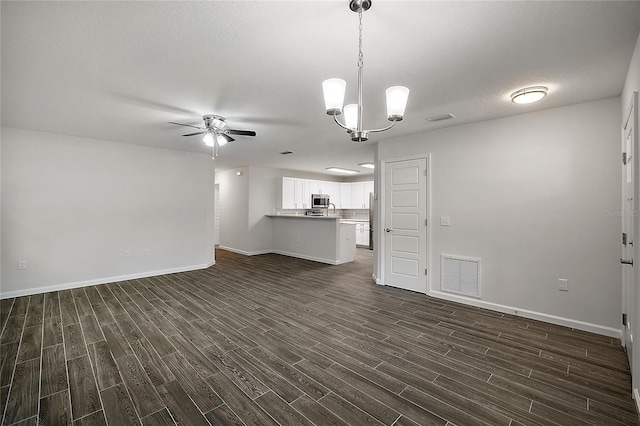 unfurnished living room featuring dark hardwood / wood-style flooring and ceiling fan with notable chandelier