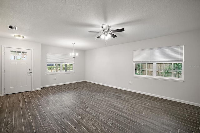 spare room featuring a textured ceiling, dark hardwood / wood-style floors, and ceiling fan with notable chandelier