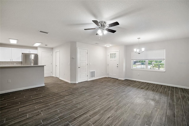 unfurnished living room featuring a textured ceiling, dark hardwood / wood-style floors, and ceiling fan with notable chandelier