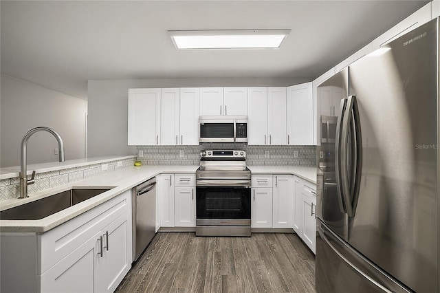 kitchen featuring kitchen peninsula, sink, white cabinets, and appliances with stainless steel finishes