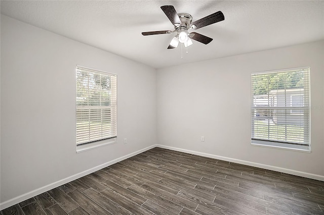 empty room with dark hardwood / wood-style floors and ceiling fan