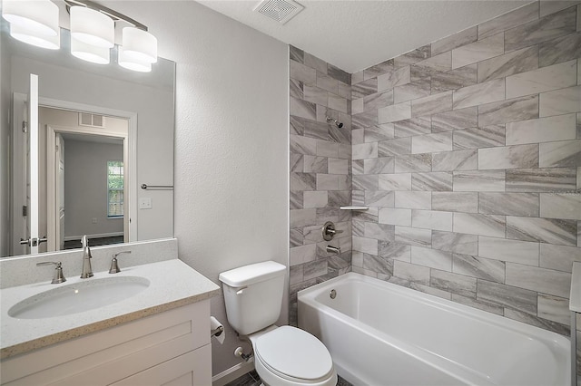 full bathroom with a textured ceiling, vanity, toilet, and tiled shower / bath