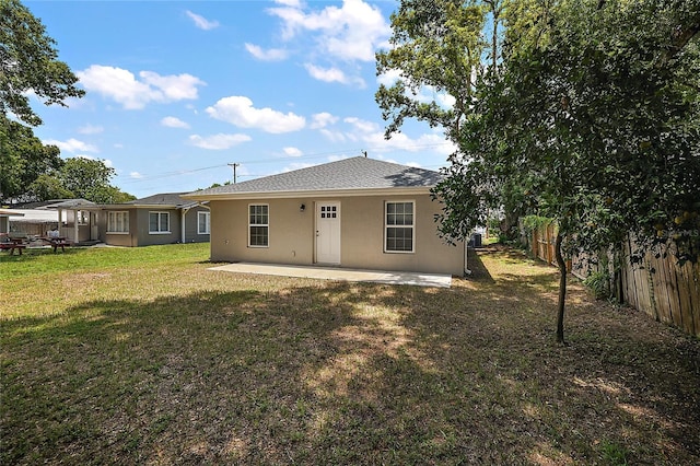 rear view of property featuring a yard and a patio