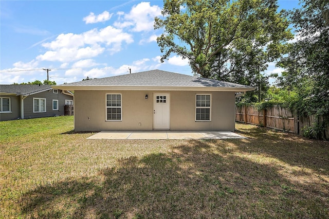 rear view of property with a lawn and a patio