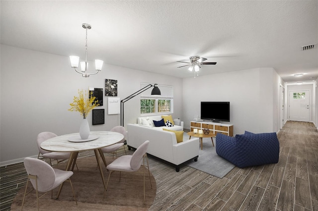 living room with a textured ceiling and ceiling fan with notable chandelier