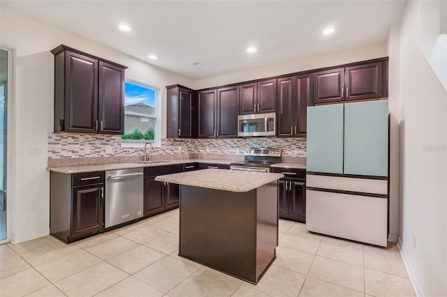 kitchen featuring sink, a center island, light tile patterned floors, dark brown cabinetry, and stainless steel appliances