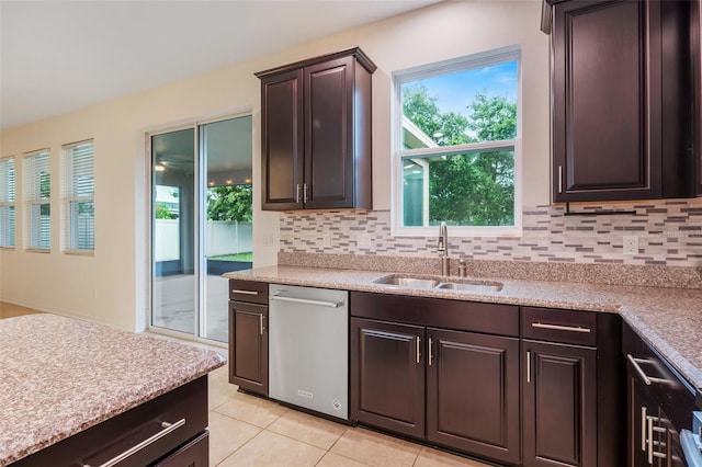 kitchen with dark brown cabinetry, sink, light tile patterned floors, dishwasher, and backsplash