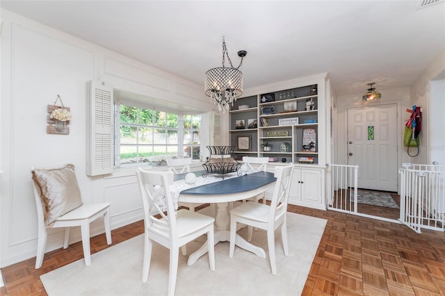 dining space featuring dark parquet floors and a chandelier