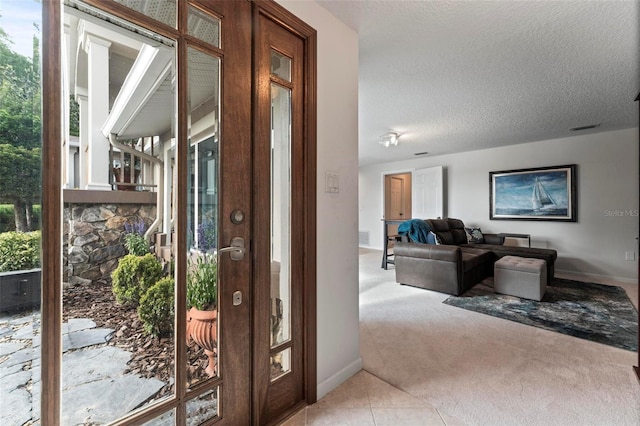 doorway to outside with carpet and a textured ceiling