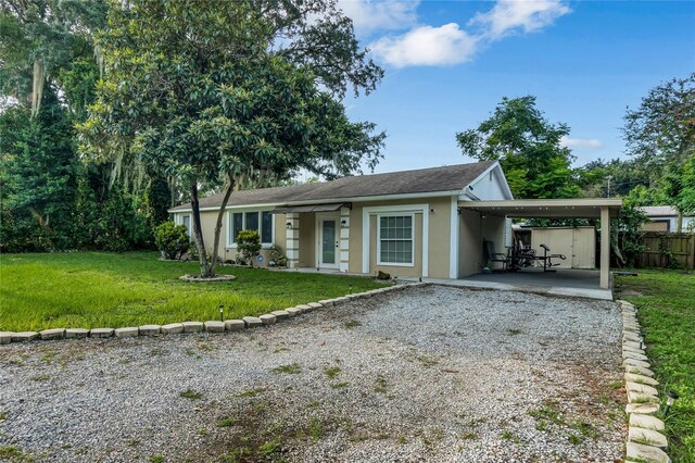 ranch-style house featuring a front yard and a carport