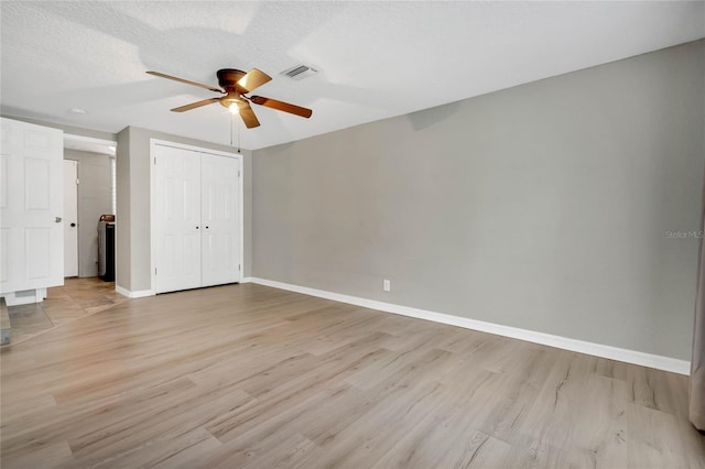 unfurnished bedroom with light hardwood / wood-style flooring, a textured ceiling, a closet, and ceiling fan