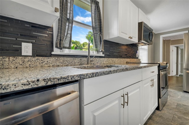 kitchen featuring stainless steel appliances, white cabinets, light stone countertops, tasteful backsplash, and tile patterned floors