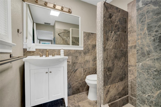 bathroom featuring tile walls, toilet, tile patterned floors, and vanity