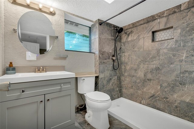 bathroom featuring tile patterned floors, a textured ceiling, vanity, and toilet