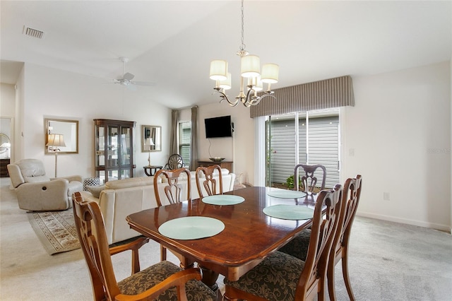 carpeted dining area with ceiling fan with notable chandelier and vaulted ceiling