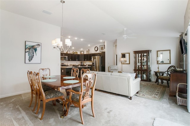 dining space with vaulted ceiling, ceiling fan with notable chandelier, and light carpet