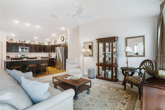 living room with light wood-type flooring, ceiling fan, and lofted ceiling