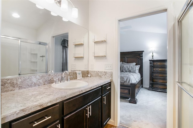 bathroom featuring a shower with shower door and vanity